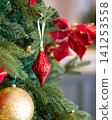 Red christmas ornaments and gold colored balls on xmas tree. 141253558