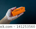 Thank you note on orange paper on the palm of a hand. 141253560