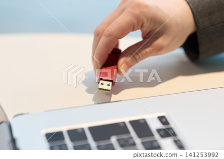 Inserting a USB memory stick into a computer 141253992