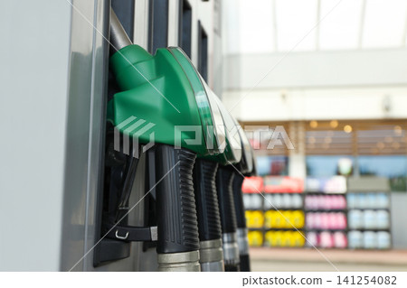 Green fuel nozzle is ready at a modern refueling station 141254082