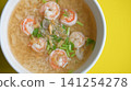rice soup with shrimp in white bowl on yellow background 141254278