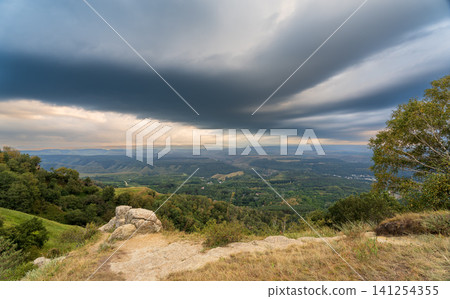 A mountain range covered in the wild woods illuminated by the golden light of the setting sun. A natural Park reserve or hunting grounds. Recreational outdoor tourism 141254355