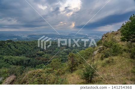 A mountain range covered in the wild woods illuminated by the golden light of the setting sun. A natural Park reserve or hunting grounds. Recreational outdoor tourism A mountain range covered in the wild woods illuminated by the golden light of the setting sun. A natural Park reserve or hunting grounds. Recreational outdoor tourism 141254368