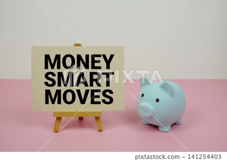 Money Smart Moves text written on paper card with easel and piggy bank 141254403