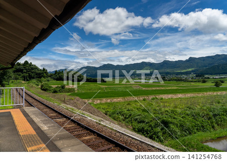 A view of the early summer blue sky and the beautiful rural landscape of Aso from a local train station. A view of the early summer blue sky and the beautiful rural landscape of Aso from a local train station. 141254768