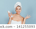 Young woman with towel wrapped around head 141255093