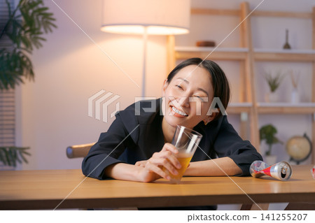一個穿著西裝的女人喝啤酒喝醉了。 一個穿著西裝的女人喝啤酒喝醉了。 141255207