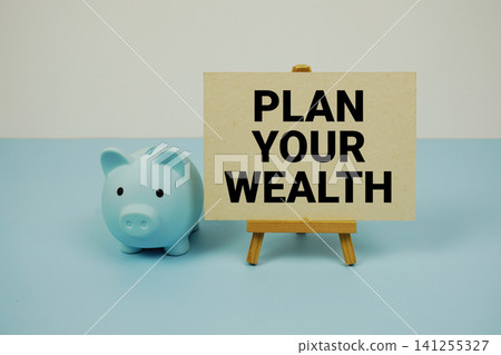 Plan Your Wealth text written on paper card with easel and piggy bank Plan Your Wealth text written on paper card with easel and piggy bank 141255327