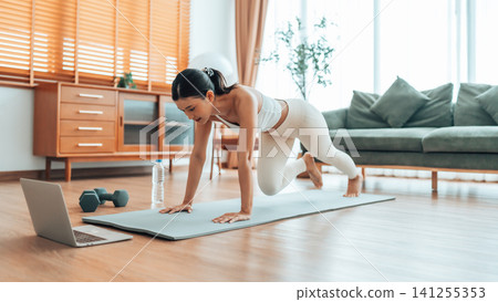 Young Asian woman doing sport exercises indoor Young Asian woman doing sport exercises indoor 141255353