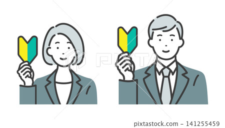 A young man and woman in suits, both holding beginner driver stickers. A young man and woman in suits, both holding beginner driver stickers. 141255459