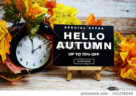 Hello Autumn Sale 70% off Special Offer text with alarm clock and maple leaf decoration on wooden background Hello Autumn Sale 70% off Special Offer text with alarm clock and maple leaf decoration on wooden background 141256849