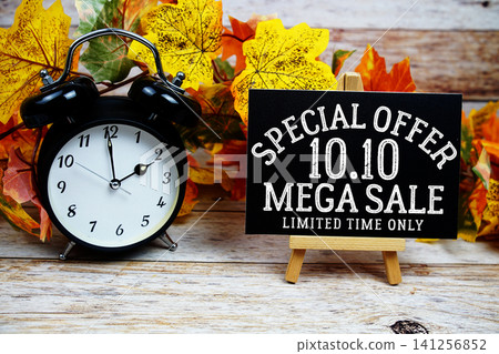 10.10 Mega Sale Special Offer text with alarm clock and maple leaf decoration on wooden background 10.10 Mega Sale Special Offer text with alarm clock and maple leaf decoration on wooden background 141256852