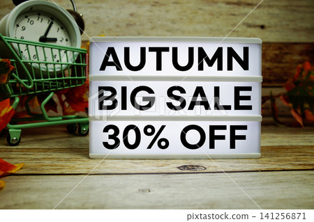 Autumn Big Sale 30% off text with trolley shopping cart and alarm clock decoration with maple leaf on wooden background Autumn Big Sale 30% off text with trolley shopping cart and alarm clock decoration with maple leaf on wooden background 141256871