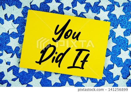 You Did It text written on paper card with star glitter on blue background You Did It text written on paper card with star glitter on blue background 141256899