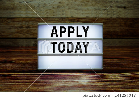 Lightbox with text "Apply Today" on wooden background 141257018