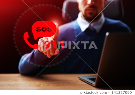 Person using computer to call emergency services with 911 and SOS displayed on the screen in a dimly lit room Person using computer to call emergency services with 911 and SOS displayed on the screen in a dimly lit room 141257090