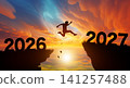 Man jumping across the gap from 2026 to 2027 cliff with Sunset and Twilight Sky background. 141257488