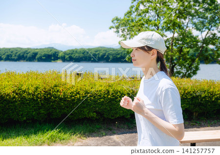 Profile of a woman running while wearing a cap Profile of a woman running while wearing a cap 141257757