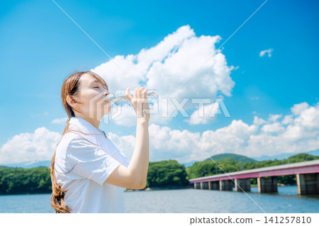 一名女子閉著眼睛喝水。 一名女子閉著眼睛喝水。 141257810