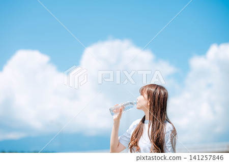 Profile of a woman drinking water from a plastic bottle Profile of a woman drinking water from a plastic bottle 141257846