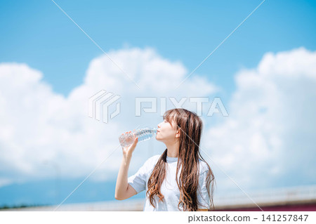 特寫鏡頭:一名女子閉著眼睛喝水。 特寫鏡頭:一名女子閉著眼睛喝水。 141257847
