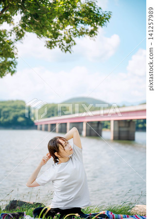 A short-haired woman gazing into the distance by the lake. A short-haired woman gazing into the distance by the lake. 141257989