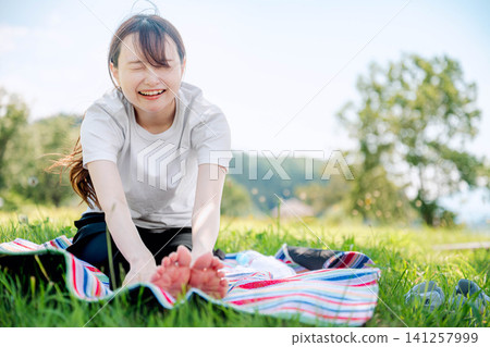A woman stretching and smiling, showing her teeth. A woman stretching and smiling, showing her teeth. 141257999