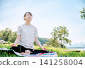 一位女子正在冥想，同時深呼吸。 141258004