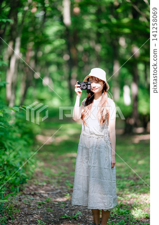 A woman wearing a hat takes a picture with her lens pointed at her. A woman wearing a hat takes a picture with her lens pointed at her. 141258069