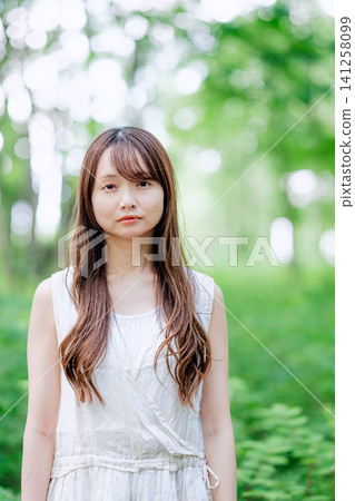一位神態平靜的女子，面向前方，置身於大自然中。 141258099