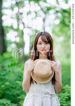 一位酷酷的女士將草帽抱在胸前。 一位酷酷的女士將草帽抱在胸前。 141258102