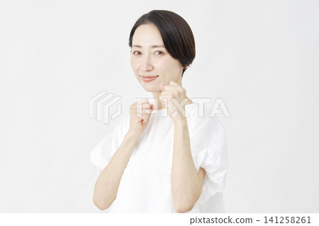 Middle-aged woman in a fighting pose against a white background. Middle-aged woman in a fighting pose against a white background. 141258261