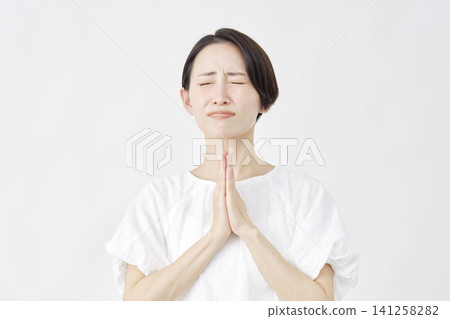 Middle-aged woman pleading, white background Middle-aged woman pleading, white background 141258282