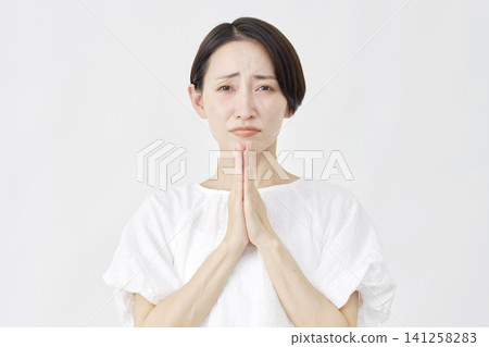 Middle-aged woman pleading, white background 141258283