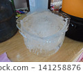 Bucket-shaped ice block on wooden countertop indoors 141258876