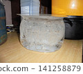 Bucket-shaped ice with crystallic structures inside standing on a kitchen unit 141258879