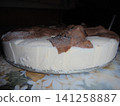 Side view on a sweet white cake with a fece-like decoration from brown dough 141258887