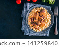 Delicious hot meatballs covered in savory gravy sauce served with bulgur or rice on a plate. Top view flat lay composition on dark textured background with copy space. Perfect for restaurant menu 141259840