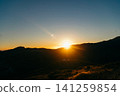 The sun shines brightly over the mountain range 141259854