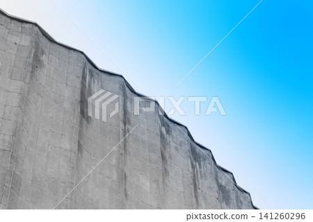 Concrete old building architecture structure cement facade apartment stone with elements of illumination bulbs on the roof against a background of sky Concrete old building architecture structure cement facade apartment stone with elements of illumination bulbs on the roof against a background of sky 141260296