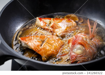 The golden snapper is being cooked in a pot. The golden snapper is being cooked in a pot. 141260322