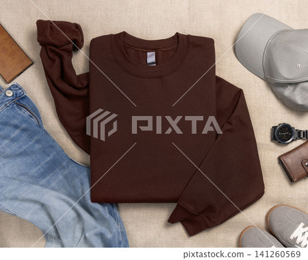 Blank brown unisex sweatshirt mockup, folded crewneck with mens accessories and sneakers Blank brown unisex sweatshirt mockup, folded crewneck with mens accessories and sneakers 141260569