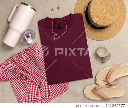 Blank dark red folded shirt mockup with woman summer accessories, template for print on demand Blank dark red folded shirt mockup with woman summer accessories, template for print on demand 141260577