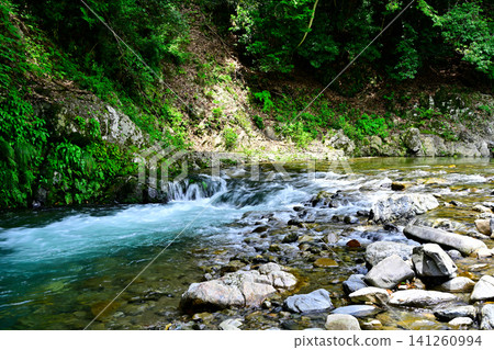 The flow of the river flowing through the valley The flow of the river flowing through the valley 141260994