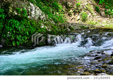 The flow of the river flowing through the valley The flow of the river flowing through the valley 141260995