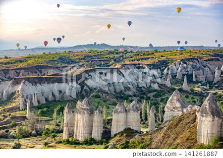 Hot air balloons float over rock formations in a landscape during sunrise in Cappadocia, Turkey. 05.11.2018. Cappadocia. Turkey Hot air balloons float over rock formations in a landscape during sunrise in Cappadocia, Turkey. 05.11.2018. Cappadocia. Turkey 141261887
