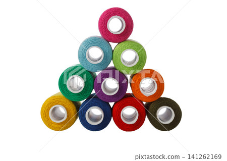 multi-colored spools of sewing thread in the form of a pyramid on a white background multi-colored spools of sewing thread in the form of a pyramid on a white background 141262169
