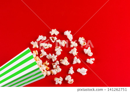 box with popcorn striped in different colors on a red background box with popcorn striped in different colors on a red background 141262751