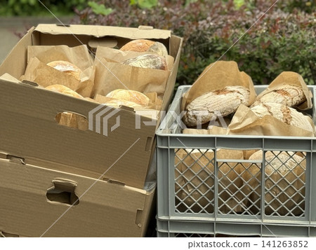 Freshly baked bread in boxes and crates outdoors, perfect for bakery or food concept background Freshly baked bread in boxes and crates outdoors, perfect for bakery or food concept background 141263852