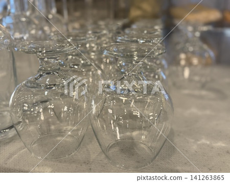 Clear wine glasses arranged upside down on a textured surface background for elegant dining setup 141263865